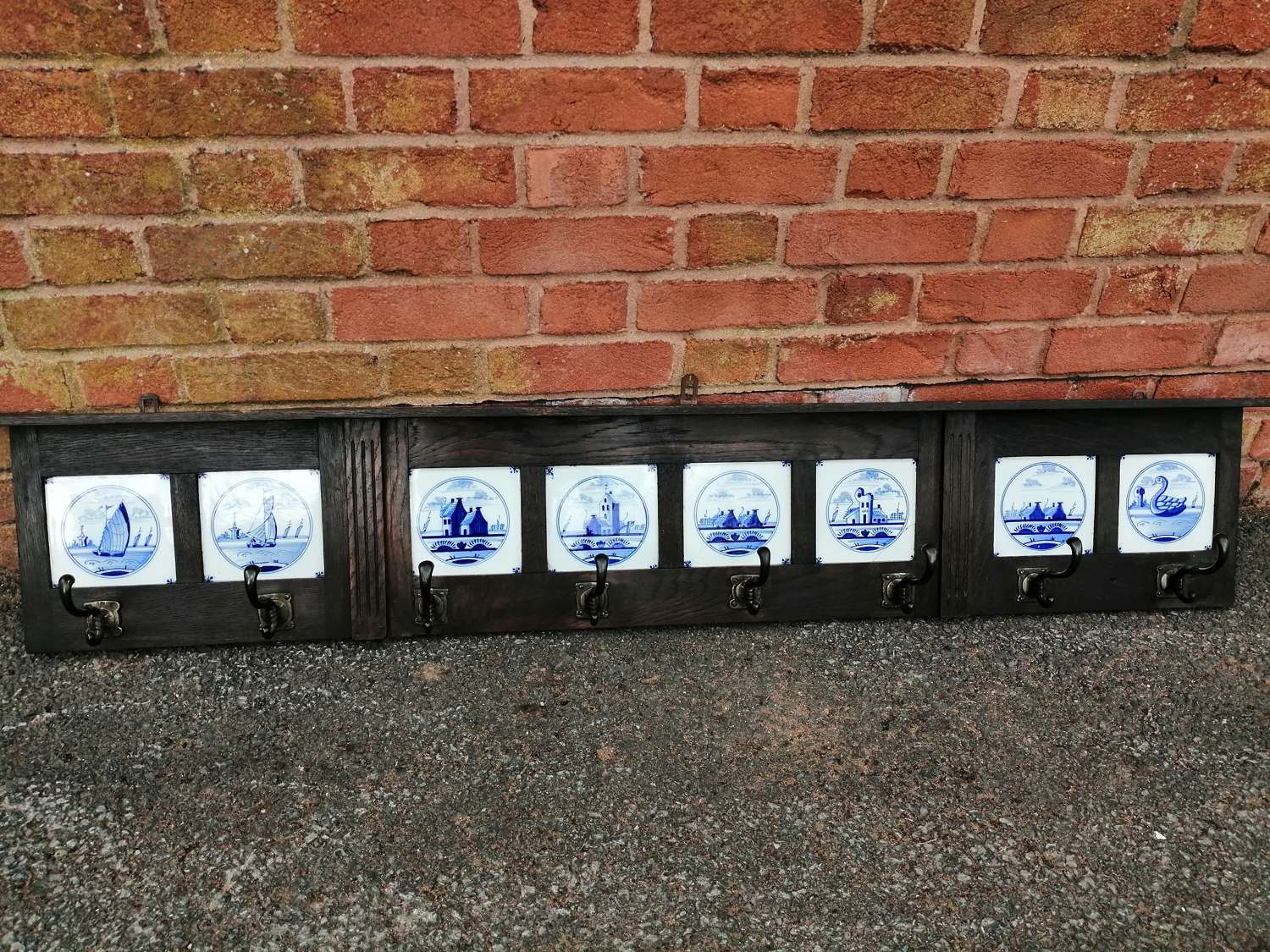 An oak framed coat rack with 8 inset Dutch Delft tiles