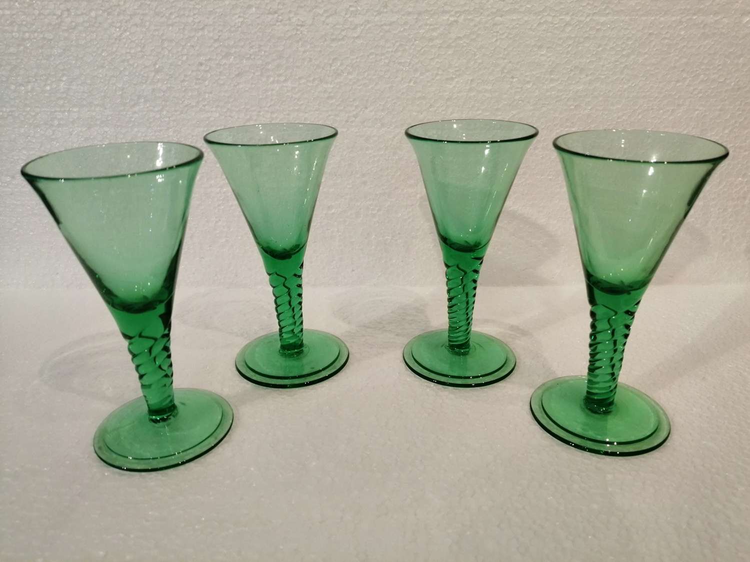 Four 19th century emerald green wine glasses